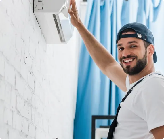 An engineer fitting a wall-mounted air conditioning unit